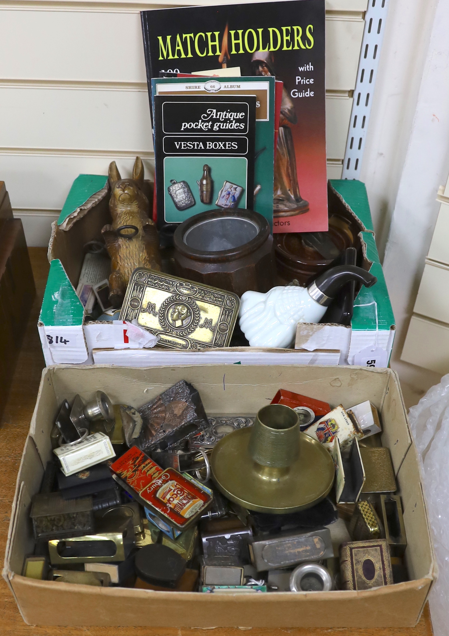 A collection of Vesta boxes, matchbox holders and other related ephemera, mostly metal examples, some with enamel panels, candle holders, wooden boxes, together with a rabbit pipe rack, tobacco jars, cigarette cases, etc